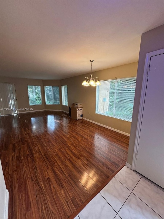 unfurnished dining area featuring light hardwood / wood-style flooring and a notable chandelier