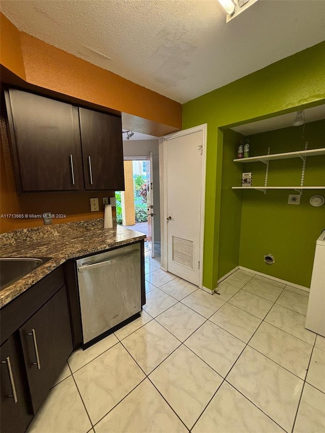 kitchen featuring sink, stainless steel dishwasher, dark stone countertops, a textured ceiling, and dark brown cabinets