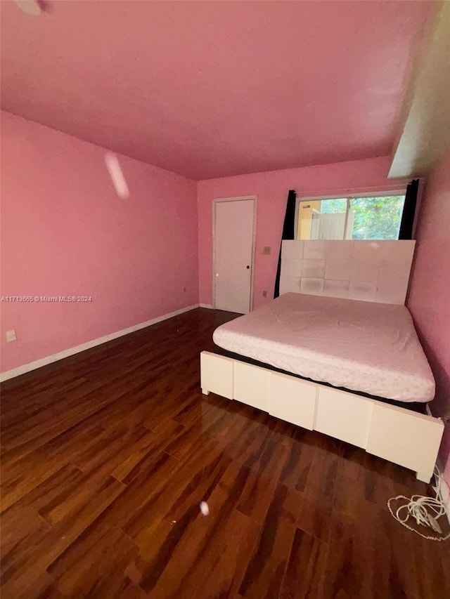 unfurnished bedroom with dark wood-type flooring