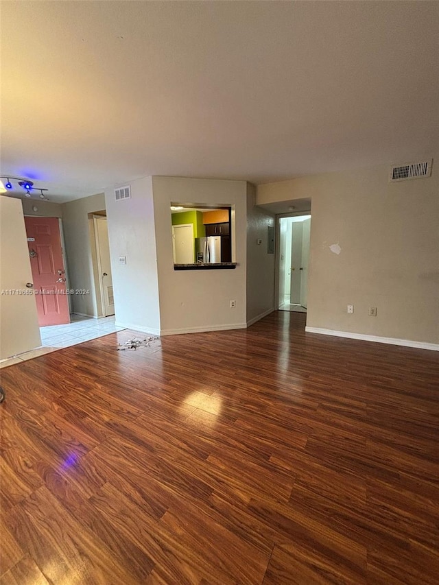 unfurnished living room with dark wood-type flooring