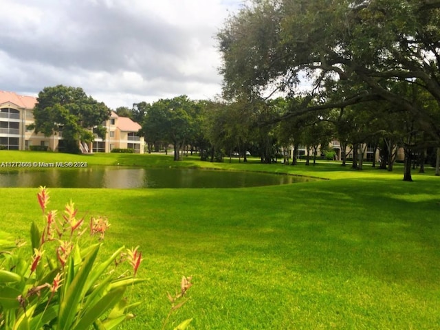 view of property's community featuring a yard and a water view