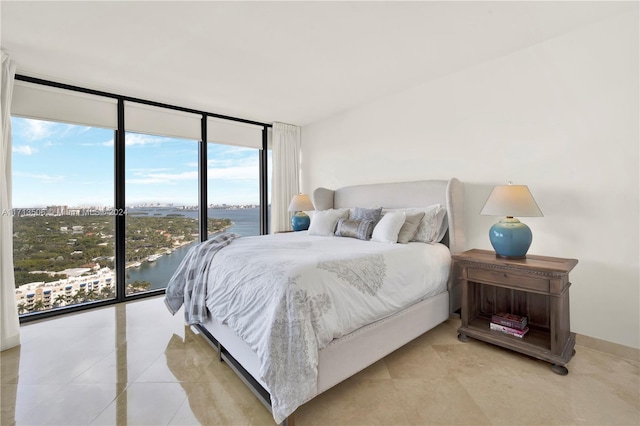 bedroom featuring a water view and floor to ceiling windows