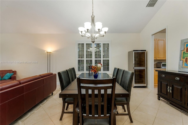 tiled dining room featuring lofted ceiling, wine cooler, and a chandelier