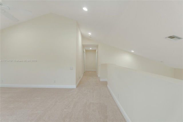 hall featuring light colored carpet and lofted ceiling