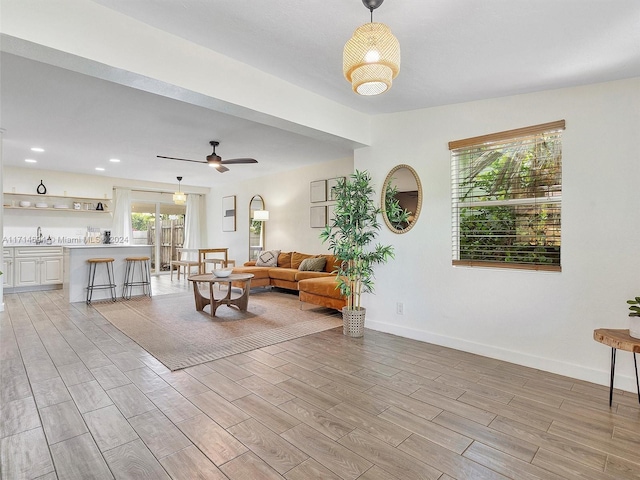 living room with ceiling fan and sink