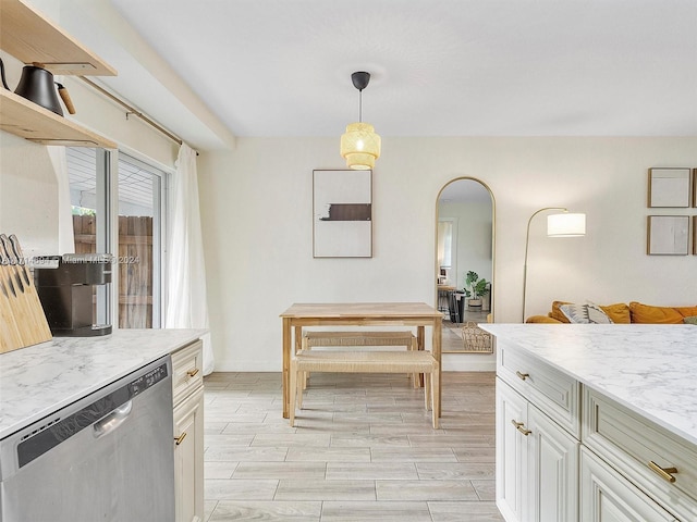 kitchen featuring light stone countertops, decorative light fixtures, stainless steel dishwasher, and white cabinetry