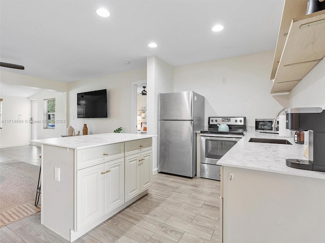 kitchen featuring white cabinetry, a center island, sink, stainless steel appliances, and a breakfast bar area