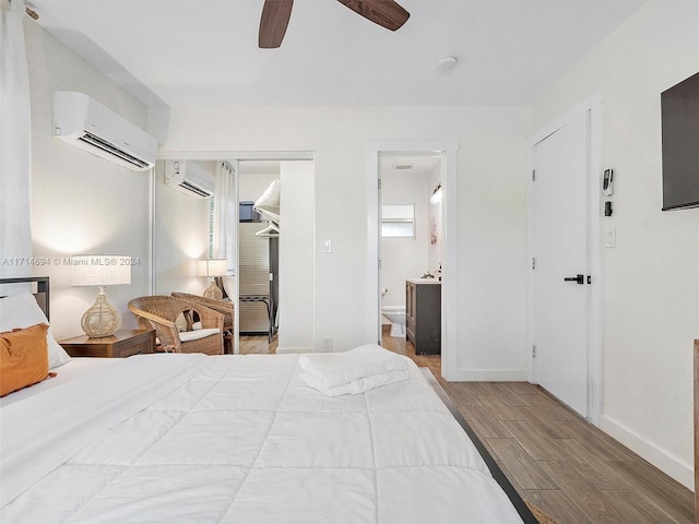 bedroom with a wall mounted air conditioner, ceiling fan, a walk in closet, and a closet