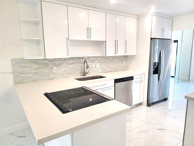 kitchen featuring sink, stainless steel appliances, backsplash, kitchen peninsula, and white cabinets