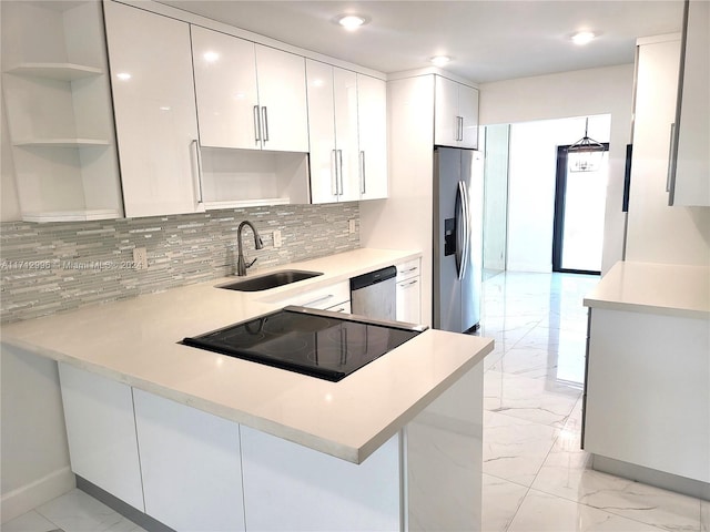 kitchen with sink, tasteful backsplash, kitchen peninsula, white cabinets, and appliances with stainless steel finishes