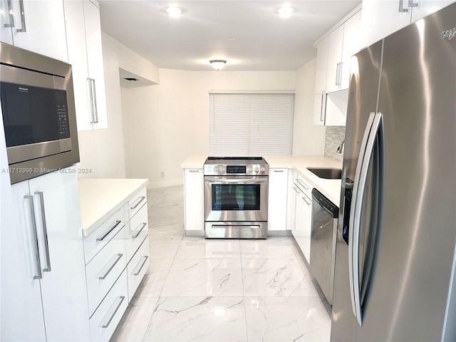 kitchen featuring appliances with stainless steel finishes, white cabinetry, and sink