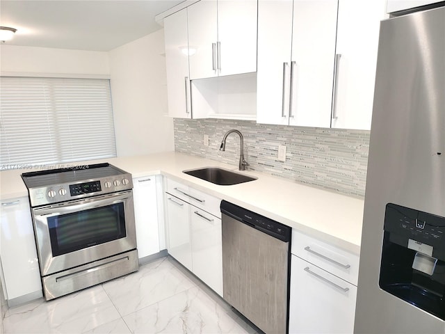 kitchen with white cabinets, appliances with stainless steel finishes, decorative backsplash, and sink