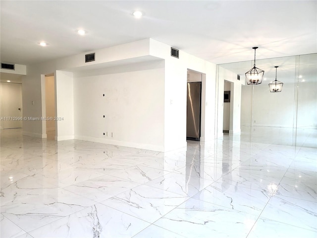 spare room featuring an inviting chandelier