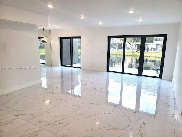 spare room featuring french doors and a water view