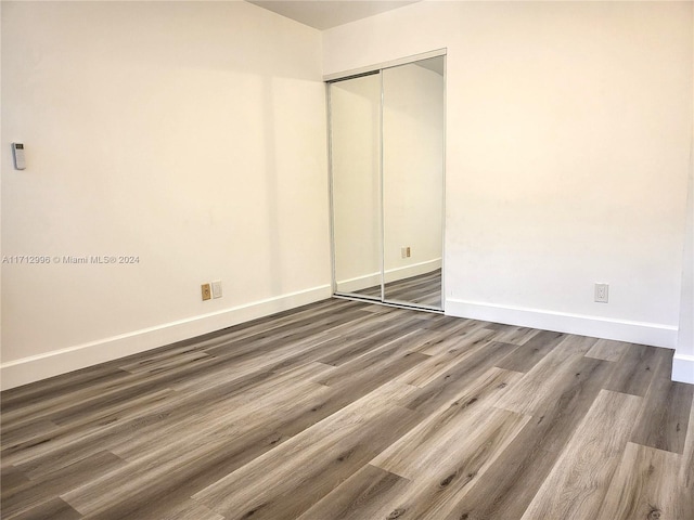 unfurnished bedroom with a closet and hardwood / wood-style flooring