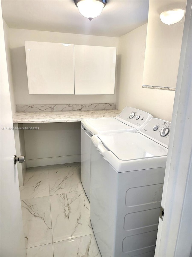 washroom featuring cabinets and separate washer and dryer