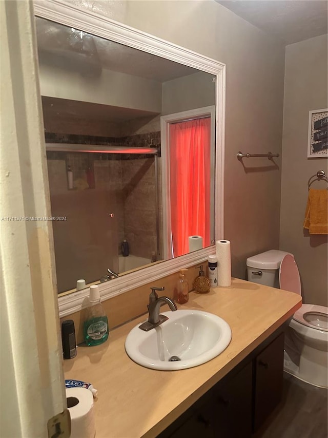 bathroom with vanity, wood-type flooring, an enclosed shower, and toilet