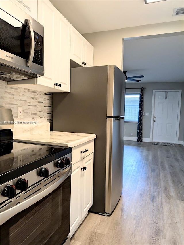 kitchen with ceiling fan, light hardwood / wood-style flooring, white cabinets, and stainless steel appliances