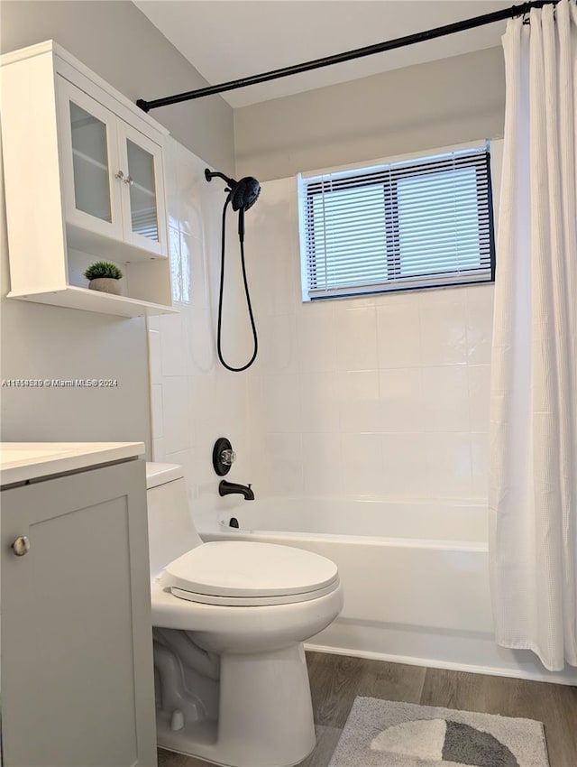 full bathroom featuring hardwood / wood-style flooring, vanity, toilet, and shower / bath combo