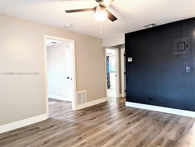 empty room with ceiling fan and hardwood / wood-style flooring