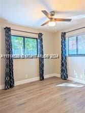 empty room with ceiling fan and hardwood / wood-style flooring