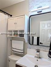 bathroom with vanity, curtained shower, and toilet