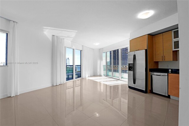 60 SW 13th St Unit 1700, Miami, FL 33130 - kitchen featuring appliances with stainless steel finishes, brown cabinetry, light tile patterned floors, and dark countertops