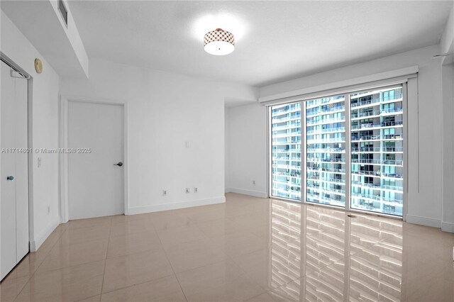 empty room featuring light tile patterned flooring and visible vents