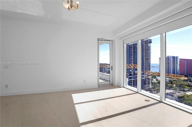 tiled empty room featuring baseboards and a city view