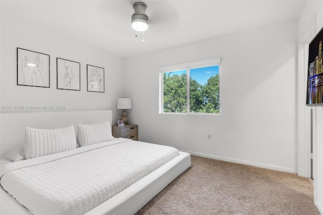 carpeted bedroom with ceiling fan and baseboards