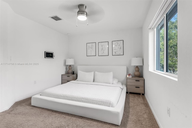 carpeted bedroom featuring baseboards, visible vents, and a ceiling fan