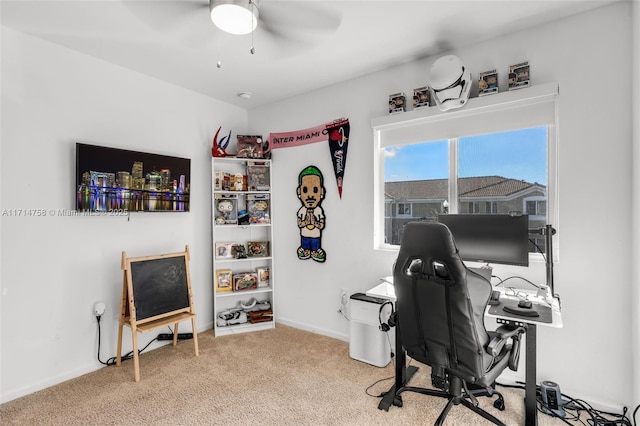 carpeted office with ceiling fan and baseboards