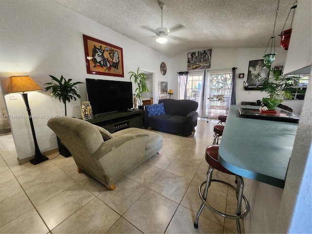 living room with ceiling fan, light tile patterned floors, a textured ceiling, and vaulted ceiling