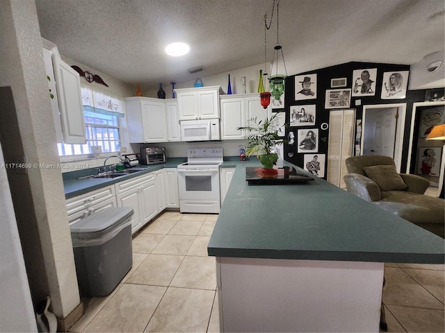 kitchen with lofted ceiling, white cabinetry, and white appliances