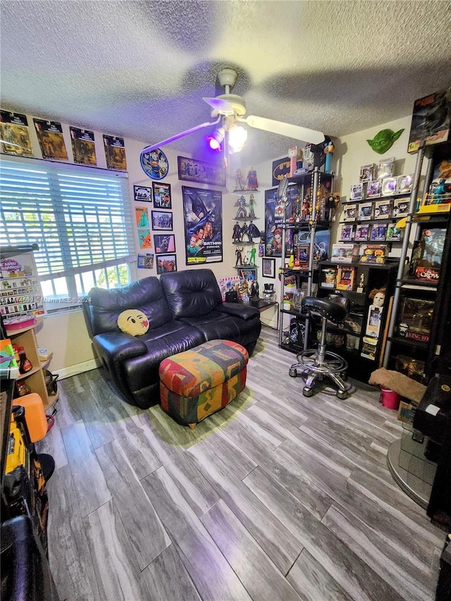 interior space with ceiling fan, hardwood / wood-style floors, and a textured ceiling