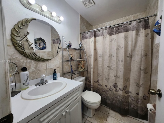 bathroom featuring decorative backsplash, tile patterned floors, vanity, tile walls, and toilet