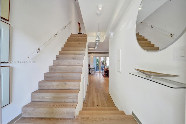 stairs featuring hardwood / wood-style floors