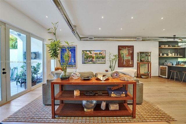 dining area with wine cooler, french doors, and light wood-type flooring