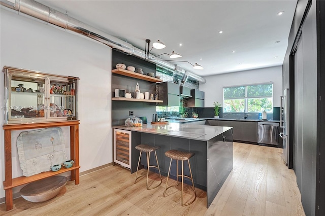 bar with dishwasher, sink, decorative backsplash, light wood-type flooring, and beverage cooler