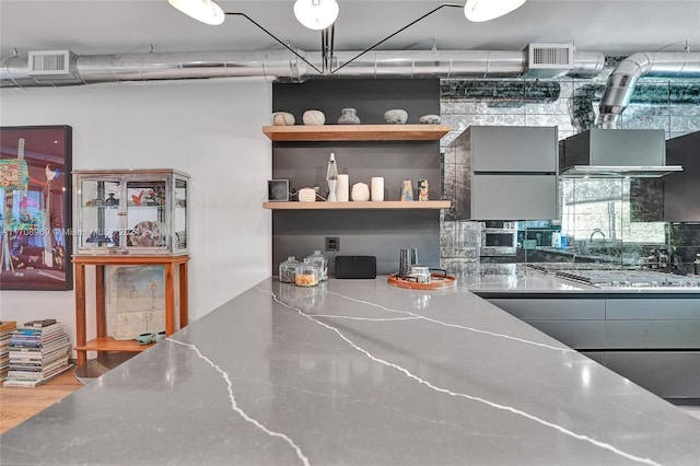 kitchen featuring hardwood / wood-style flooring and stainless steel gas stovetop