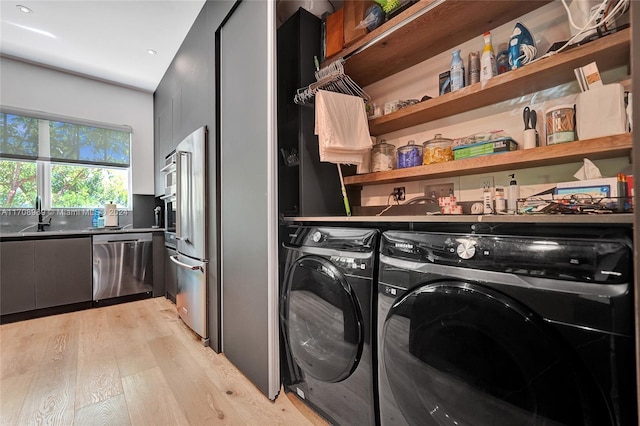 washroom featuring separate washer and dryer, light hardwood / wood-style floors, and sink