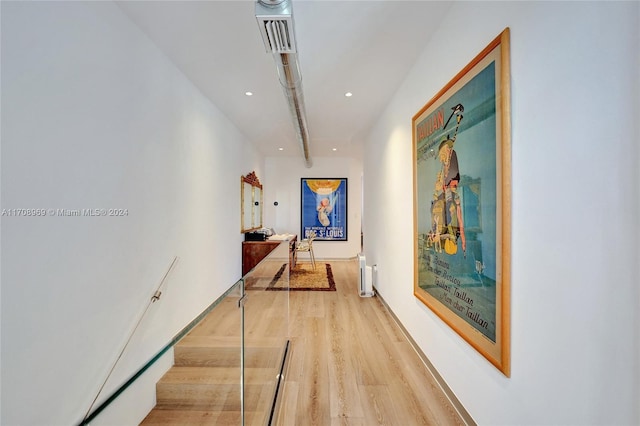 corridor with radiator heating unit and light hardwood / wood-style floors