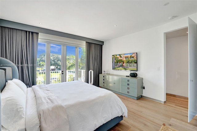 bedroom with access to exterior and light hardwood / wood-style floors