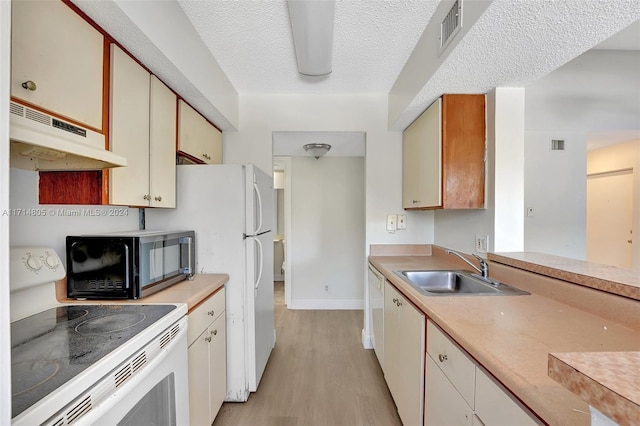 kitchen featuring a textured ceiling, light wood-type flooring, white range with electric stovetop, and sink