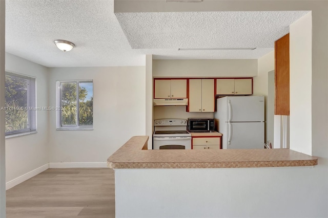 kitchen with kitchen peninsula, light hardwood / wood-style flooring, white appliances, and cream cabinetry