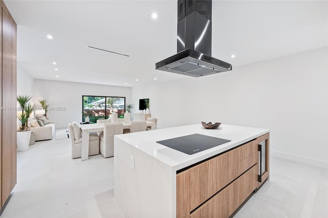 kitchen featuring black electric cooktop, island exhaust hood, and a kitchen island