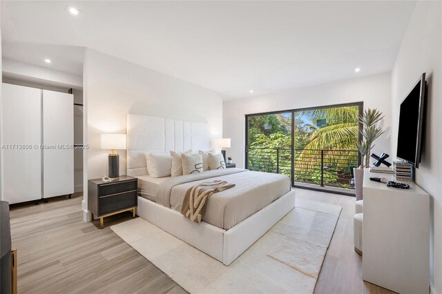 bedroom featuring light wood-type flooring and access to outside