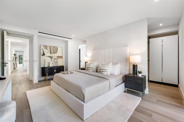 bedroom with light hardwood / wood-style flooring and a barn door