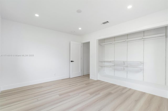 unfurnished bedroom with light hardwood / wood-style flooring and a closet