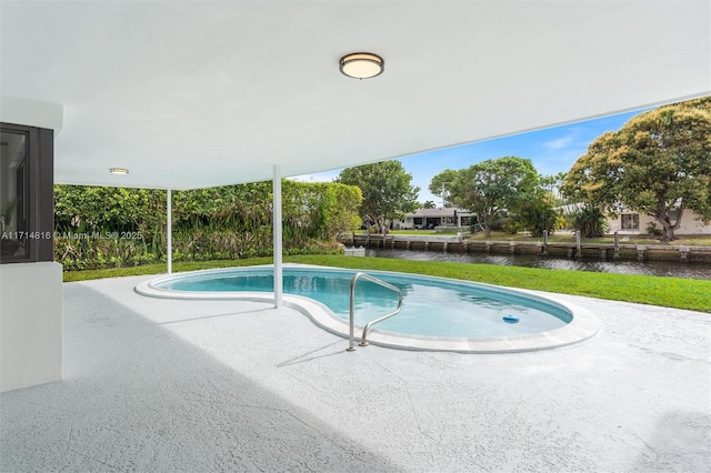 view of pool featuring a water view and a patio